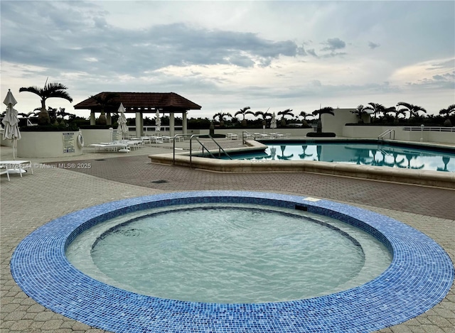 pool featuring a patio area and a hot tub