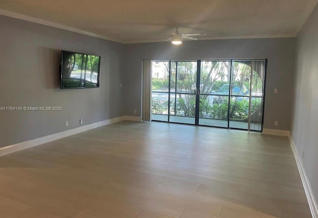 spare room featuring wood finished floors, baseboards, ornamental molding, and a ceiling fan