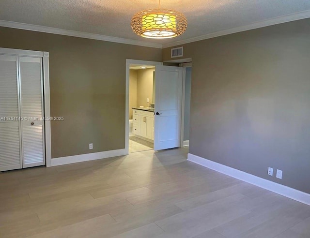 unfurnished bedroom with visible vents, crown molding, baseboards, light wood-style floors, and a textured ceiling