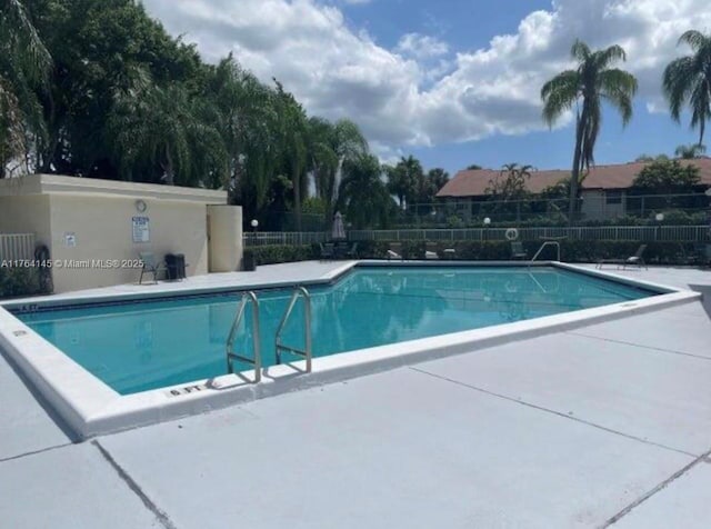 community pool with a patio and fence