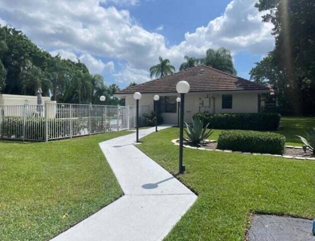 view of community featuring fence and a lawn