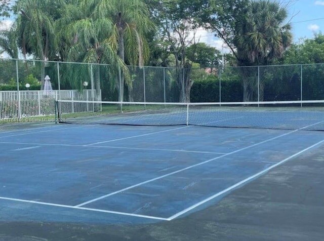 view of tennis court featuring fence