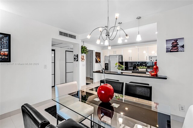 19380 Collins Ave Unit 307, Sunny Isles Beach, FL 33160 - dining space featuring an inviting chandelier, light tile patterned floors, and visible vents