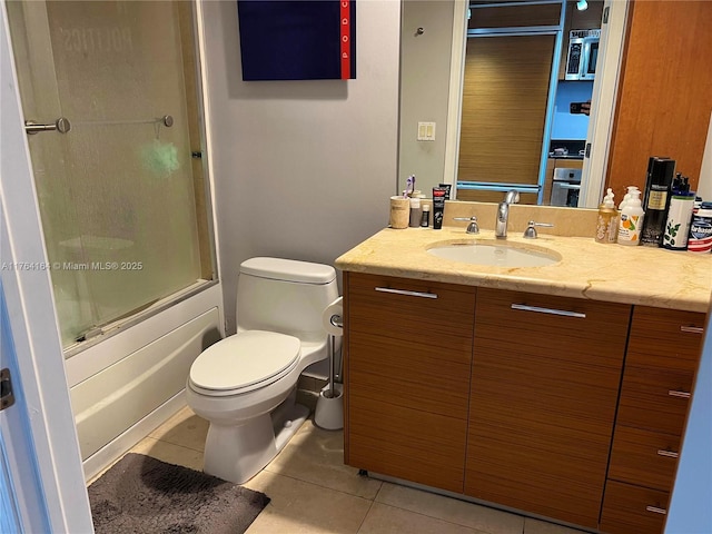 full bathroom featuring tile patterned flooring, toilet, vanity, and combined bath / shower with glass door