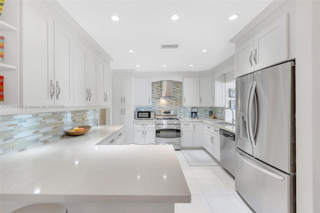 kitchen featuring visible vents, light tile patterned flooring, a sink, stainless steel appliances, and wall chimney exhaust hood