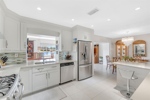 kitchen with visible vents, light countertops, appliances with stainless steel finishes, an inviting chandelier, and a sink