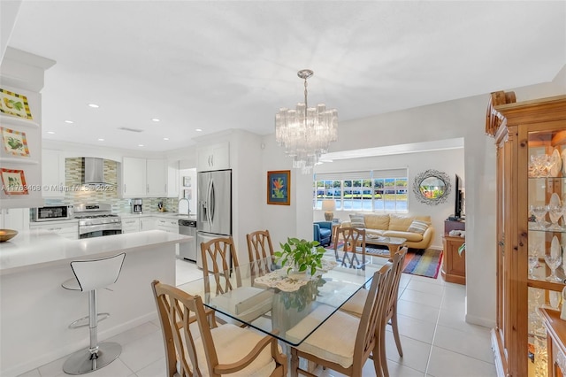 dining area with light tile patterned floors, a notable chandelier, and recessed lighting