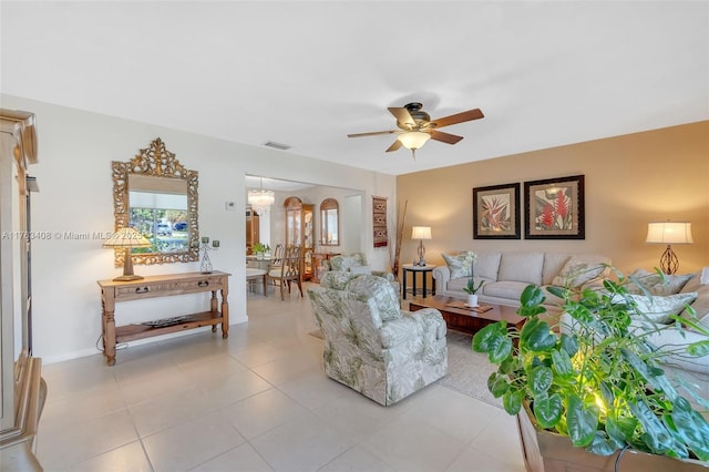 living area with light tile patterned floors, ceiling fan with notable chandelier, visible vents, and arched walkways