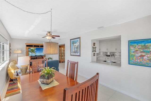 dining space with light tile patterned flooring, visible vents, baseboards, and a ceiling fan