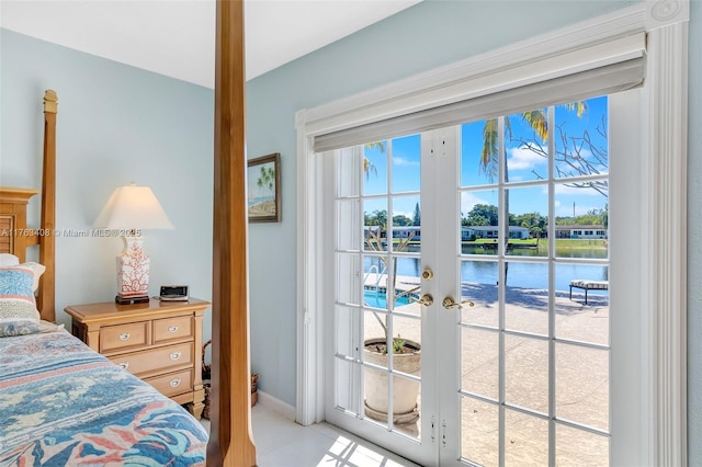 bedroom featuring french doors, a water view, multiple windows, and access to outside