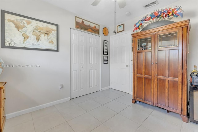 entrance foyer with light tile patterned flooring, a ceiling fan, visible vents, and baseboards