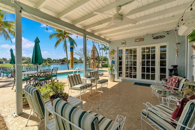 view of patio / terrace with a community pool, french doors, and a water view