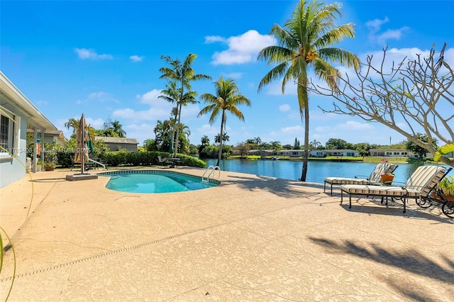 outdoor pool featuring a patio and a water view