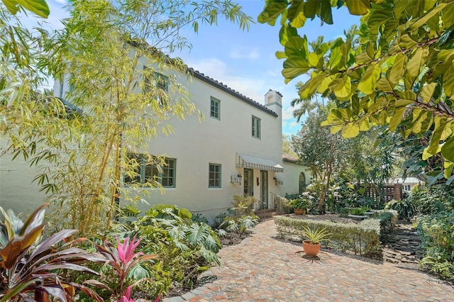 view of front of house featuring stucco siding and a chimney