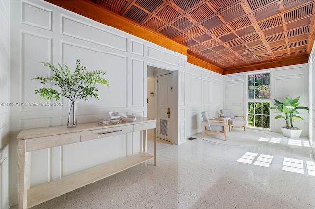 interior space with a decorative wall and light speckled floor