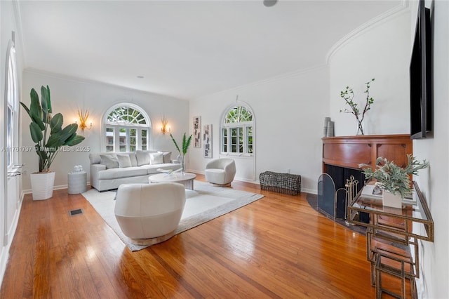 living room featuring hardwood / wood-style flooring, a wealth of natural light, and ornamental molding