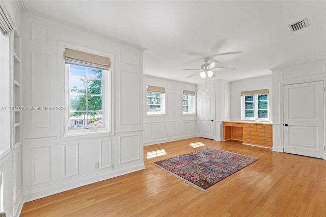 entrance foyer with light wood finished floors, visible vents, plenty of natural light, a decorative wall, and a ceiling fan