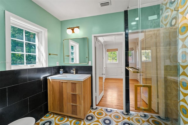 bathroom with vanity, tile walls, and visible vents