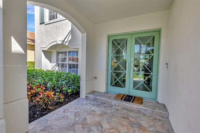 entrance to property featuring french doors and stucco siding