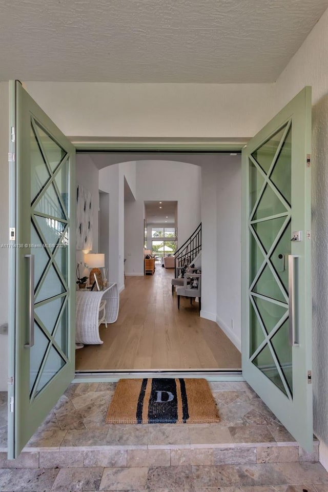 interior space with stone finish floor, arched walkways, and a textured ceiling