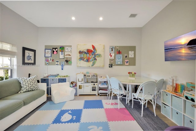 rec room with wood finished floors, recessed lighting, and visible vents