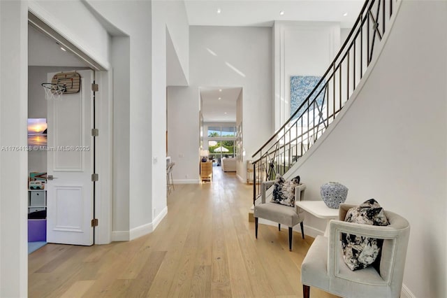 entryway featuring stairway, baseboards, and light wood finished floors