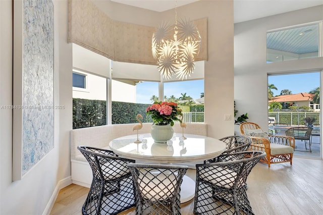 dining space with a chandelier, baseboards, and wood finished floors