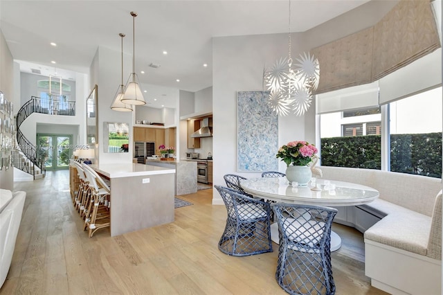 dining room featuring an inviting chandelier, a high ceiling, and light wood-style floors