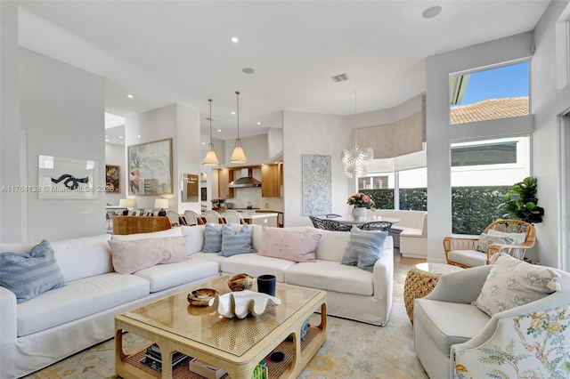 living room featuring a high ceiling, recessed lighting, a healthy amount of sunlight, and visible vents