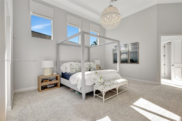 carpeted bedroom featuring baseboards, a high ceiling, an inviting chandelier, and ornamental molding