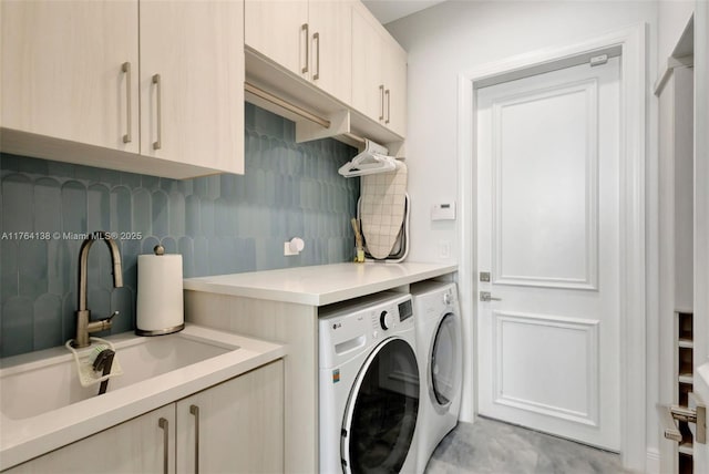 clothes washing area featuring a sink, cabinet space, and washer and clothes dryer