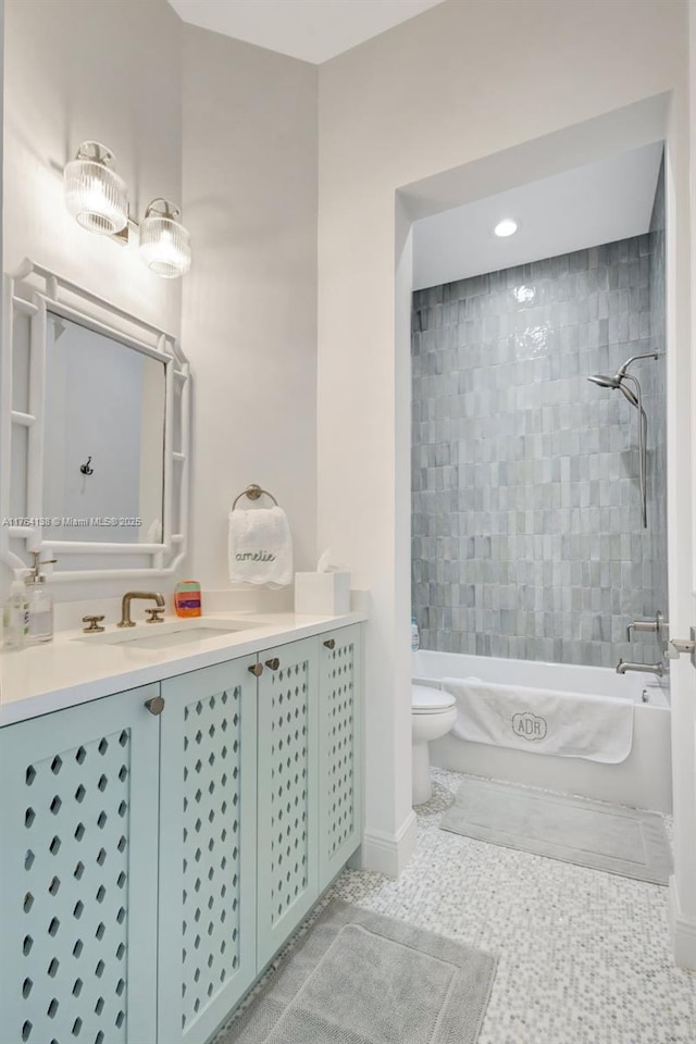 bathroom featuring vanity, baseboards, bathtub / shower combination, tile patterned floors, and toilet