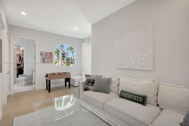 living room featuring recessed lighting, baseboards, and light wood-style flooring