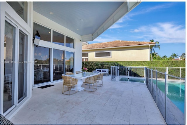 view of patio with outdoor dining space and a fenced in pool