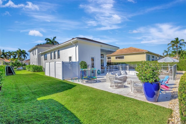 rear view of property with a patio, fence, a yard, stucco siding, and outdoor lounge area