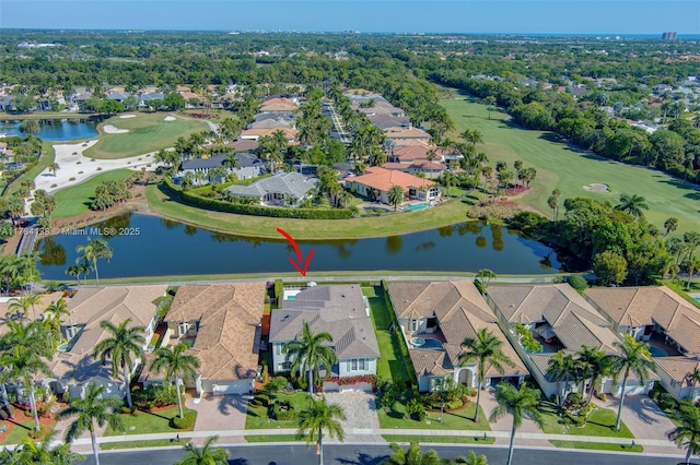 drone / aerial view with view of golf course, a residential view, and a water view