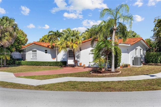 mediterranean / spanish-style home featuring stucco siding, a tile roof, and central AC