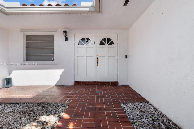 view of exterior entry with stucco siding