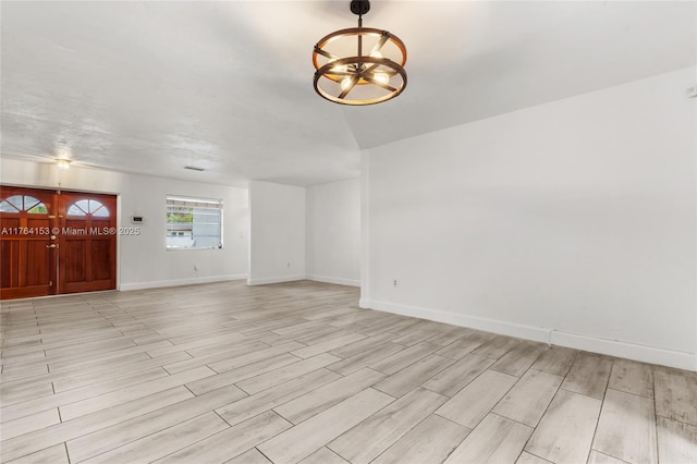 interior space with a chandelier, light wood-style flooring, and baseboards