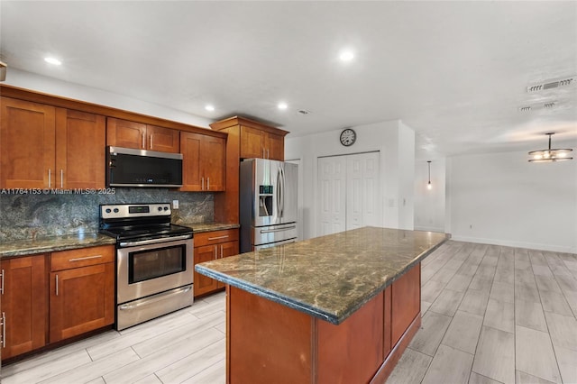 kitchen with decorative backsplash, brown cabinets, appliances with stainless steel finishes, and visible vents