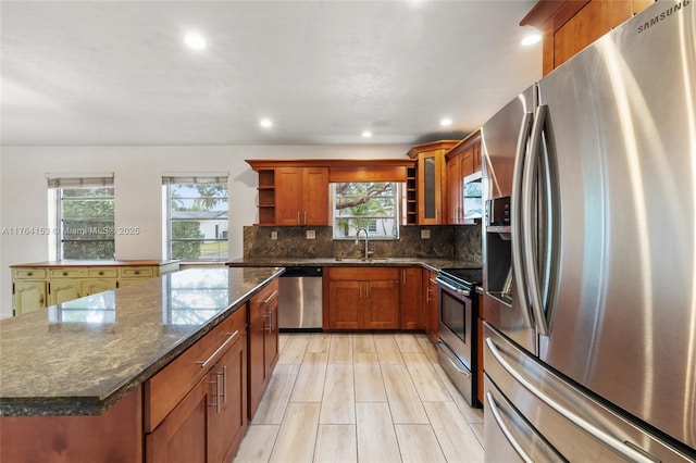 kitchen featuring open shelves, dark stone countertops, tasteful backsplash, a kitchen island, and appliances with stainless steel finishes