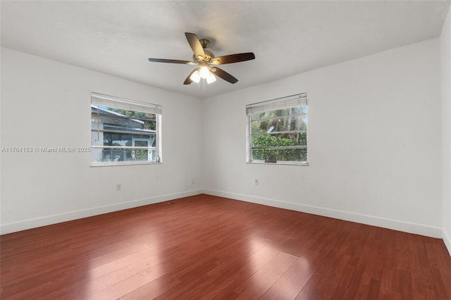 empty room with wood finished floors, baseboards, and ceiling fan