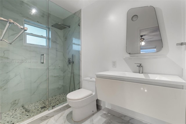 full bath featuring a marble finish shower, marble finish floor, toilet, and ceiling fan