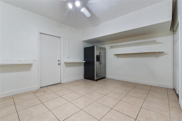 unfurnished room with light tile patterned floors, baseboards, and ceiling fan