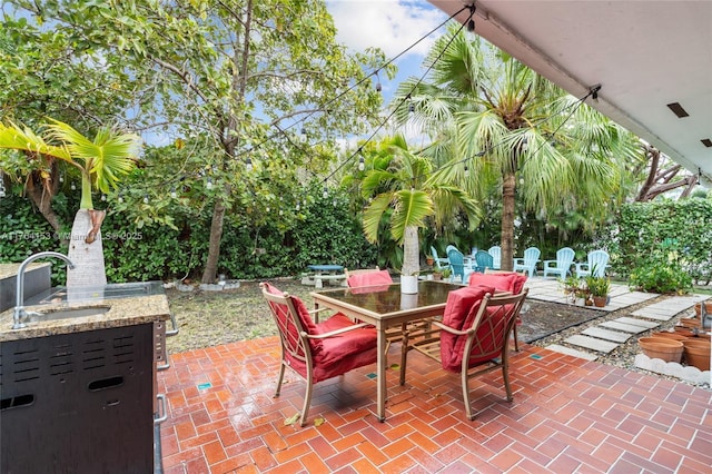 view of patio with outdoor dining area and a sink