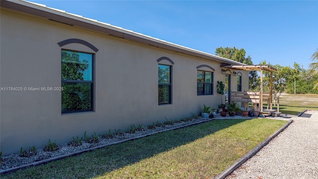 view of home's exterior featuring stucco siding and a yard