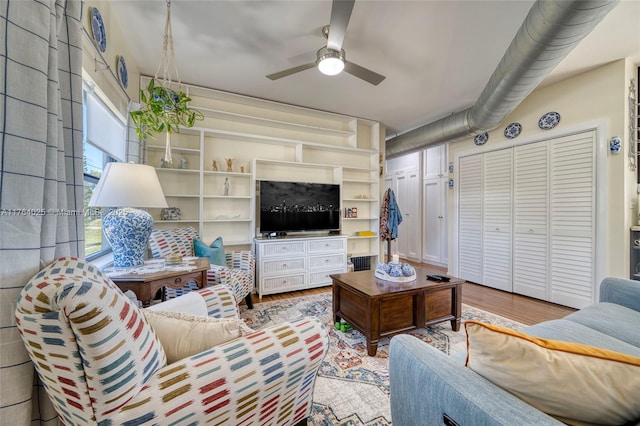 living area with wood finished floors and ceiling fan