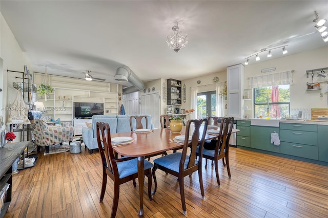 dining area with ceiling fan with notable chandelier and light wood finished floors