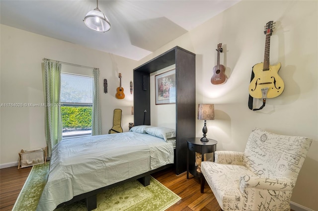 bedroom featuring wood finished floors and baseboards