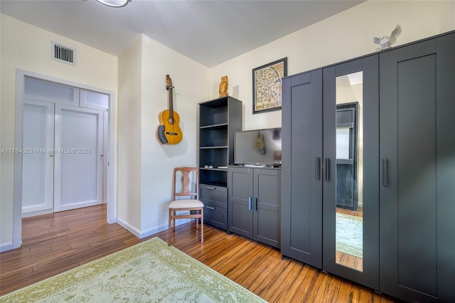 kitchen featuring visible vents, baseboards, and wood finished floors